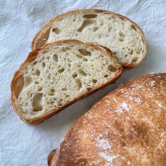 artisan sourdough boule loaf sliced with crumb